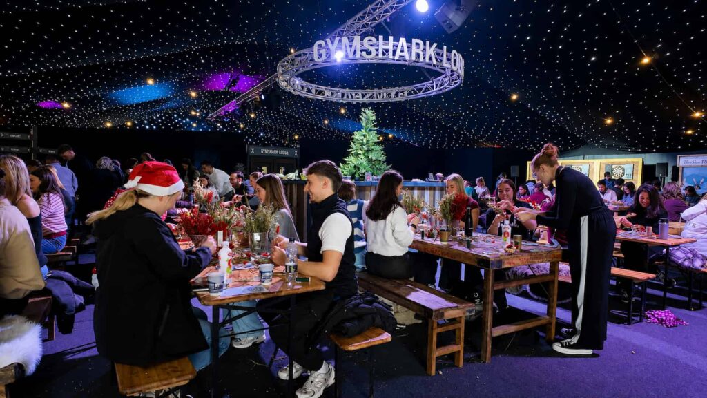 Employees taking part in a wreath-making activity at the Gymshark Lodge Christmas team event