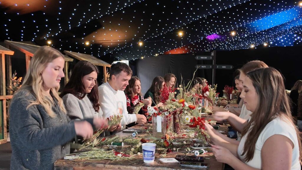 Guests taking part in a wreath making activity at a corporate Christmas event