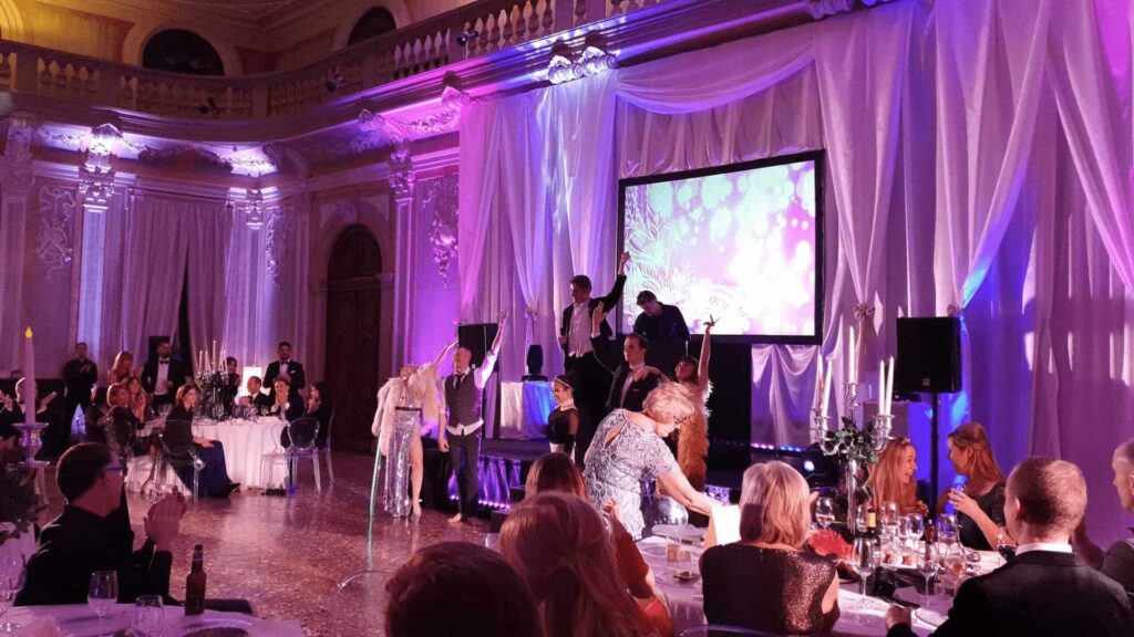 Cabaret performers taking applause on stage at a corporate gala dinner.