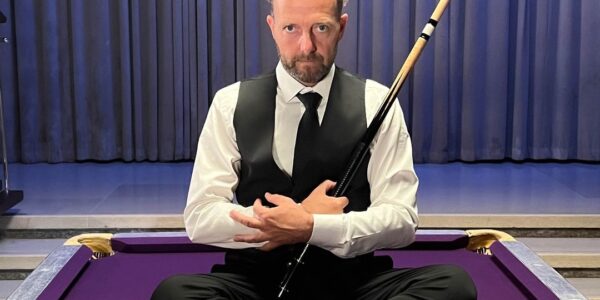 Pool-Champion-Seated-On-Pool-Table